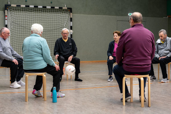 Bewegungstraining beim Lungensport des BSV Achim: Älterer Mann spielt im Sitzen mit einem Ball.