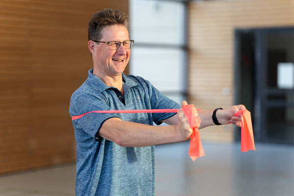 Teilnehmer des BSV Achim trainiert im Herz- und Rehasport mit Theraband zur Verbesserung von Kraft und Beweglichkeit.