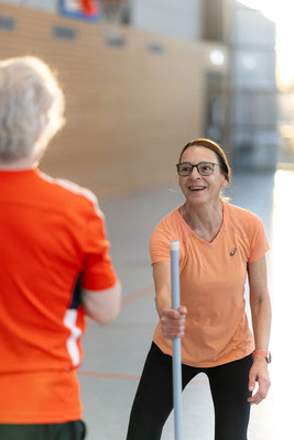 Zwei Teilnehmerinnen der Herz- und Rehasportgruppe des BSV Achim führen eine koordinative Partnerübung mit Trainingsstab durch.