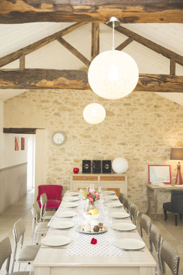salle à manger spacieuse avec pierres apparentes et poutres en chêne @lecorbeau-photo.com