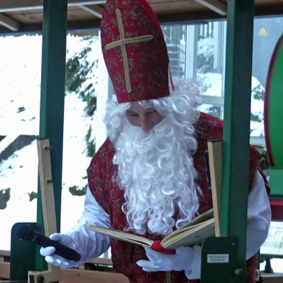 Sankt Nikolaus ist eingetroffen und liest aus seinem dicken Buch