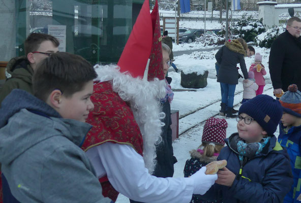 Der Nikolaus reicht diesem Jungen einen Stutenkerl