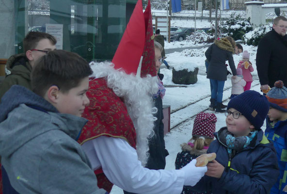 Der Nikolaus reicht diesem Jungen einen Stutenkerl