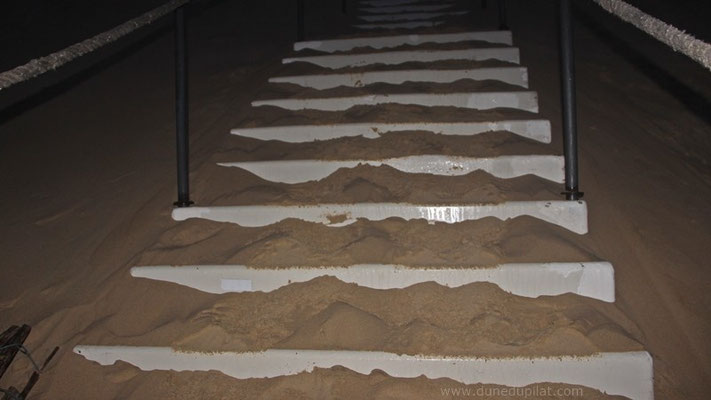 Installées il y a à peine quelques jours, les marches de l'escalier sont déjà pleines de sable ! Dur, dur...