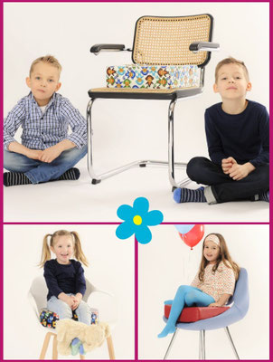 Verschiedene Stühle mit passenden Sitzerhöhungen, auf denen Kinder sitzen