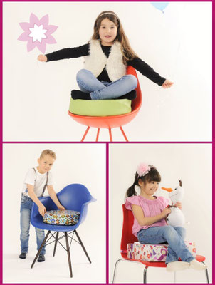 Verschiedene Stühle mit passenden Sitzerhöhungen, auf denen Kinder sitzen