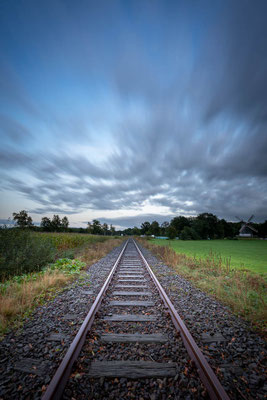 Der Abendhimmel über den Bahnschienen der Moorexpress-Strecke bei Worpswede in einer Langzeitbelichtung