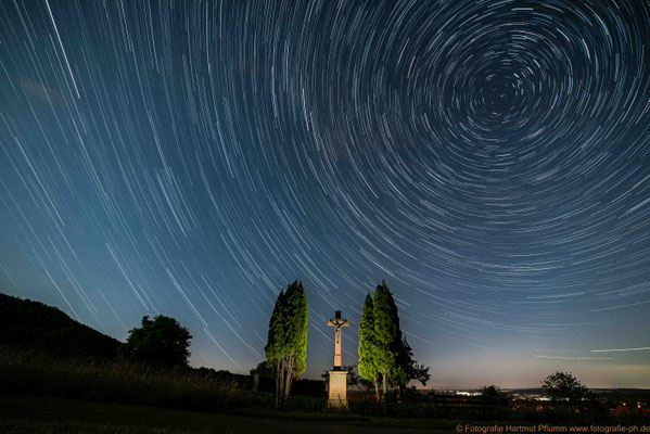 Startrail mit einem Feldkreuz am Wegesrand