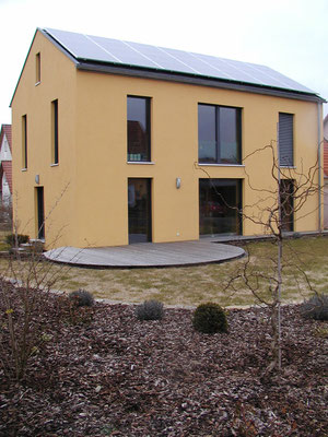 Passivhaus Kürnach- Südwest-Ansicht mit Süd-Terrasse und Außenanlagen