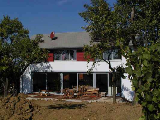 Effizienzhaus Obernbreit- süd-Ansicht mit Blick auf die Holzterrasse bei Anlage des Gartens