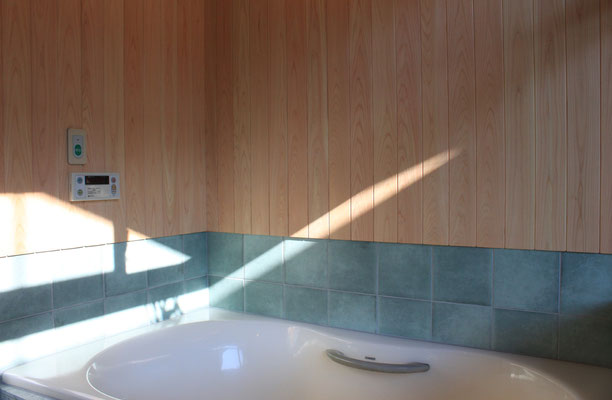 浴室内の床は十和田石、腰壁はタイルと桧、浴槽は既存再利用