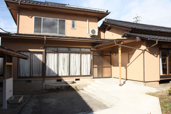 敷地の高低差により玄関前には階段が必要となった　手前には新設したスロープがある