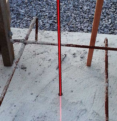 A laser shows that the center axis pole is perfectly plumb in one plane. To ensure that the pole is vertical in all planes, the laser plane must be moved 90 degrees on the pole.