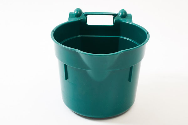 Grüner Eimer mit Haken zum Einhängen im Stall