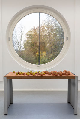 Flood, 2022. Installation with apples, clay, table of wood and metal
