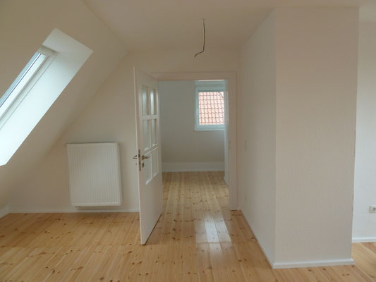 Dachgeschoss mit geschliffenem und versiegeltem Dielenboden nach der Sanierung