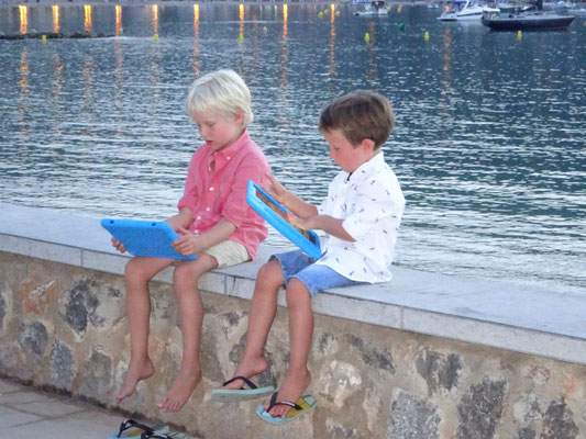 Little busy kids in the bay of Port de Soller