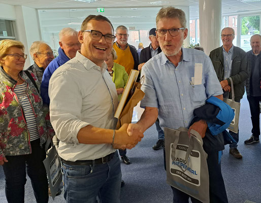 Theo Sander übergibt als Dank eine Flasche und ein Buch