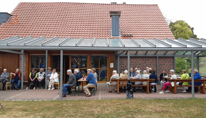 Die Gäste verteilen sich bei dem herrlichen Wetter unter der Terrasssenüberdachung ...