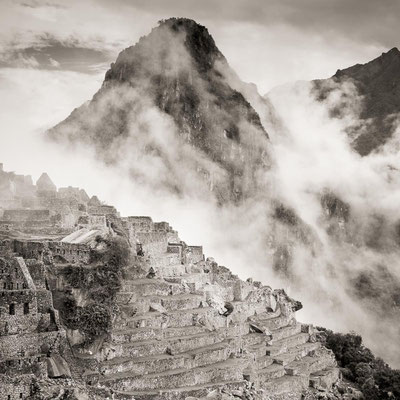 Peru: Die Terrassen von Machu Picchu. Nebel zieht aus dem Tal hoch.