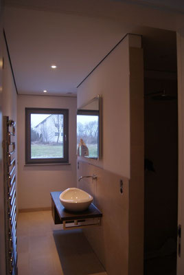 Blick in das Gäste-WC, der Waschtisch mit Spiegel und der Handtuchheizkörper wurden montiert
