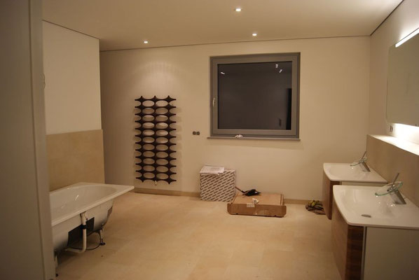 Blick in das Bad mit montierten Waschtischen, installiertem Heizkörper und aufgestellter Wanne