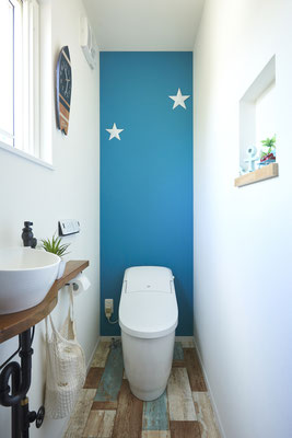 奥様お気に入りのトイレ空間。背面の青い壁紙が一番のお気に入り。