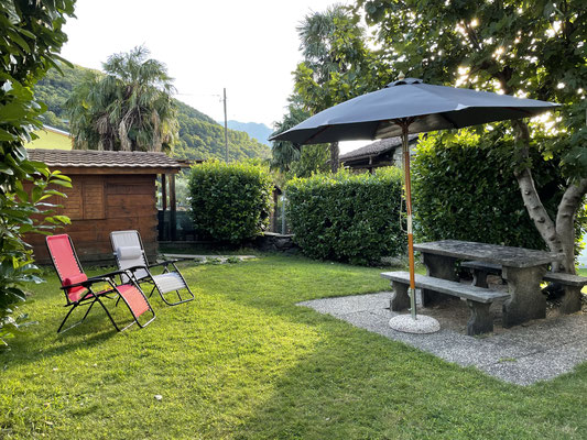 Steintisch und Gartenhaus