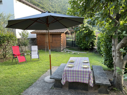Steintisch und Gartenhaus