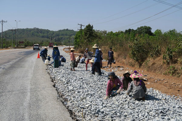 Travail de forçat pour étaler les cailloux sur la route avant de couler le goudron