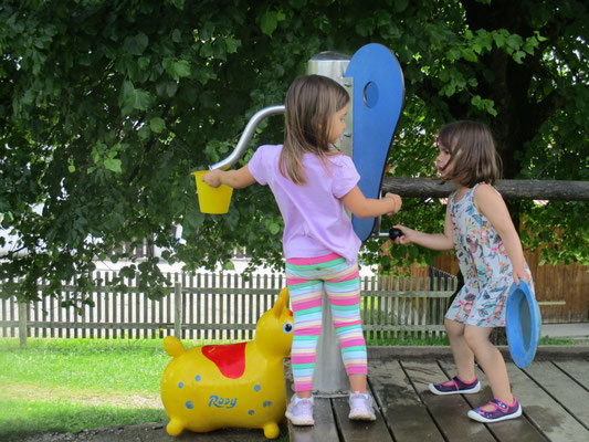 2 Kinder an der Wasserpumpe