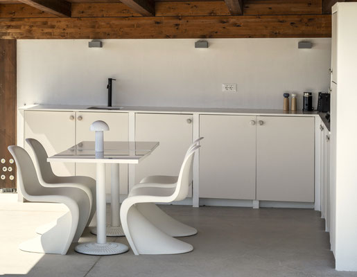 De buitenkeuken aan het zwembad met panton stoelen van Vitra