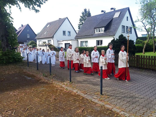 Messdiener und Kommunionkinder ziehen über die Kortenstr. zur Kirche