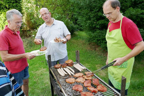 Die GR-Mitglieder Dr. Raimund Pahs (Mitte) und Andreas Gockel (r.) bedienen heute den Grill