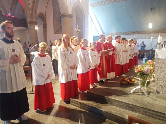Geistliche und Messdiener und Messdienerinnen vor dem Auszug aus der hochsommerlich erwärmten Kirche