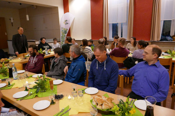 Blick in den Gemeindesaal mit Gästen beim Mahl