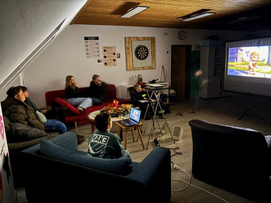 Blick in den Pfadfinderraum, in dem sich die Jugendlichen und Kinder den Film "Oben" ansehen.