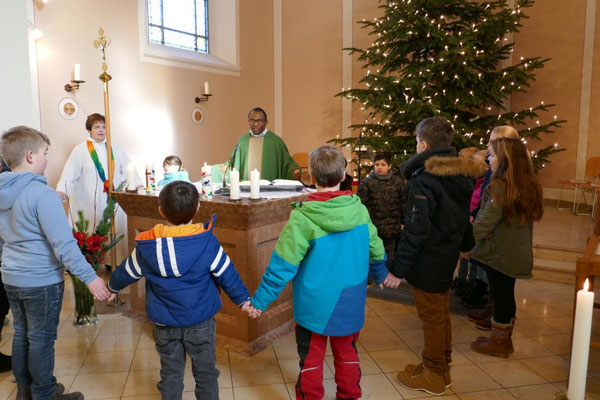 Kommunionkinder beim "Vater unser" um den Altar
