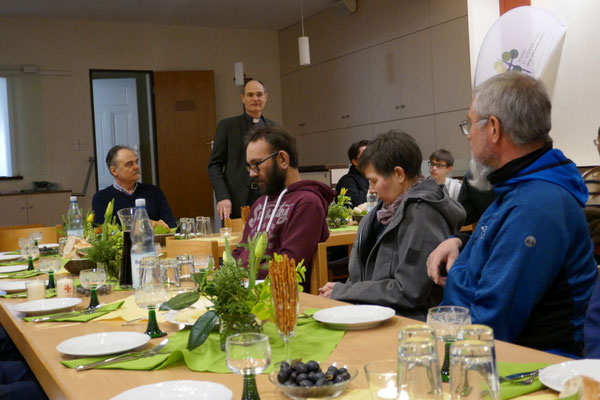 Pfarrer Schmitz begrüßt im Gemeindeheim die Anwesenden zum Agape-Mahl