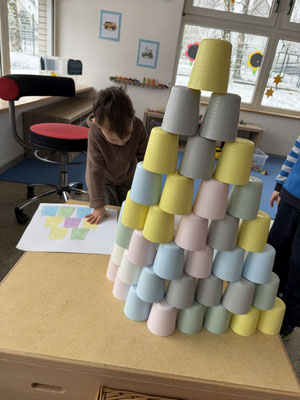 Kreative Arbeit: Gelbe und blaue Töpfe sind zu einem Turm in Pyramidenform aufeinander gestapelt