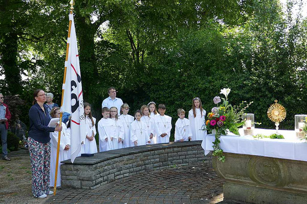 Erstkommunionkinder säumen den Friedhofsaltar