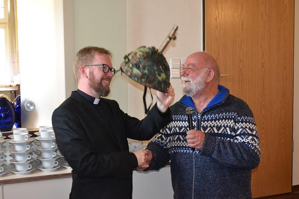 ... und übergibt dem zukünftigen Militärgeistlichen einen Helm mit Kreuz