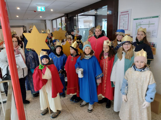 Hier sehen wir die Sternsinger, die im Flur des Rathauses ihre Lieder singen und den Segensspruch sagen.