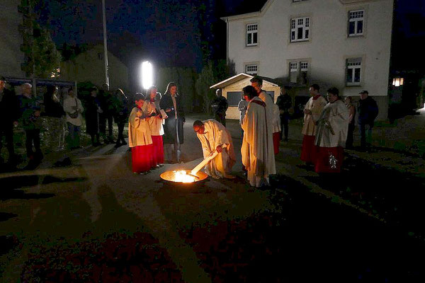 Beim wiederholten Versuch, die Osterkerze im Feuer zu entzünden