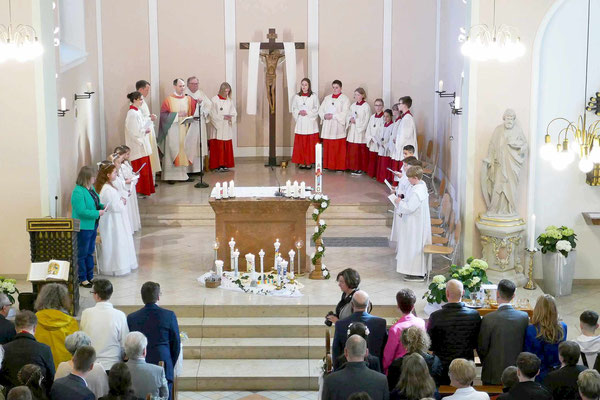 Die Gruppe im Halbkreis um den Altar: Katechetin, Erstkommunionkinder, Geistliche sowie Ministranten und Ministrantinnen