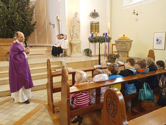 Pfarrer Schmitz unterhält sich im Rahmen der Predigt mit den Kindern