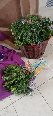 Zu sehen ist ein Korb, in dem fertig gebastelte Palmsträuße aufbewahrt werden.