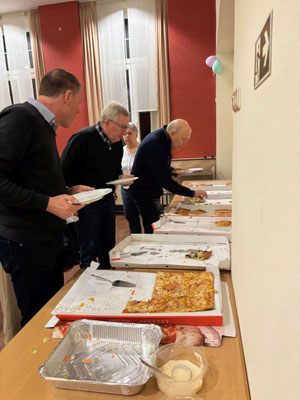 Filmabendbesucher füllen sich ihre Teller am Pizzabüfett