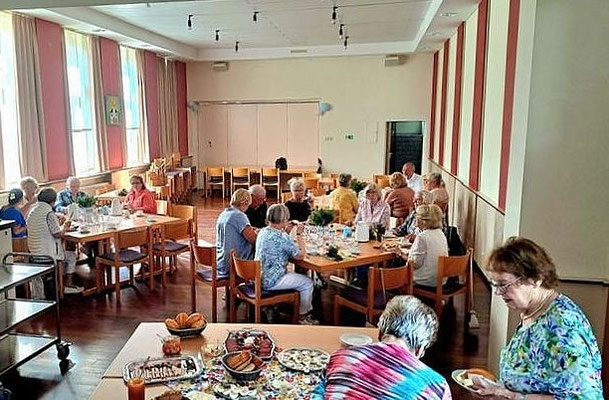 Gottesdienstbesucher und -besucherinnen beim gemeinsamen Frühstück nach der Hl. Messe