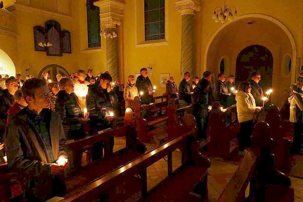 Zahlreiche Kerzen der Gläubigen erhellen den Kirchraum